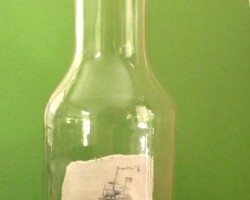 Scrimshaw of a ship in full sail in a bottle