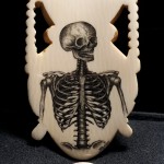 Jason's finished scrimshaw skeleton on ivory with quarter to show scale