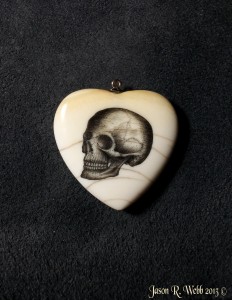 Ivory heart with a skull scrimshawed on it's face. by Jason R. Webb