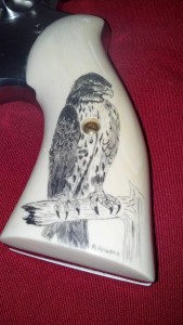 Scrimshaw pistol grip by R. Heinrich of a falcon perched on a branch
