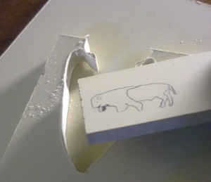 Paper micarta - scrimshaw buffalo on slab, on top of thick cut paper micarta sheet