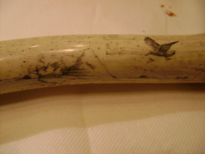 Portion of mystery artist scrimshaw 19 featuring something in the water and a bird to the right
