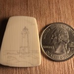 Lighthouse stippled onto galalith cabochon next to a quarter