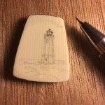 Scrimshaw lighthouse on galalith with tool to the right