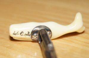 The back of the other carved ivory cufflink with the initials W.E.S.